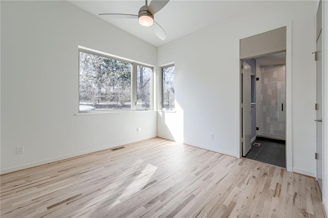 unfurnished bedroom with wood finished floors, visible vents, baseboards, ceiling fan, and connected bathroom