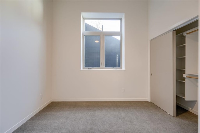 unfurnished bedroom with a closet, baseboards, and carpet flooring