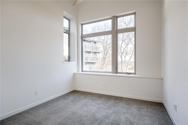 carpeted spare room with a wealth of natural light and baseboards