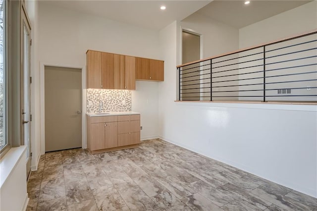 unfurnished room with a sink, baseboards, and recessed lighting