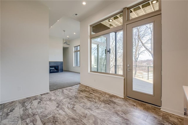 doorway to outside with visible vents, a fireplace, baseboards, and ceiling fan