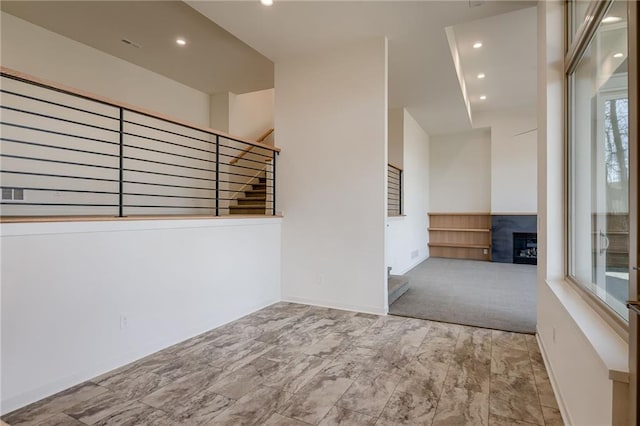 unfurnished room with stairs, baseboards, recessed lighting, and a fireplace