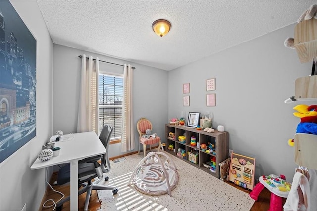 office space featuring a textured ceiling, visible vents, and baseboards