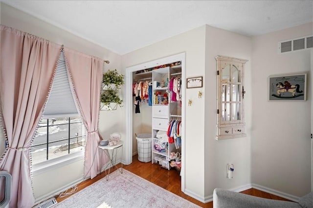 bedroom with baseboards, a closet, visible vents, and wood finished floors