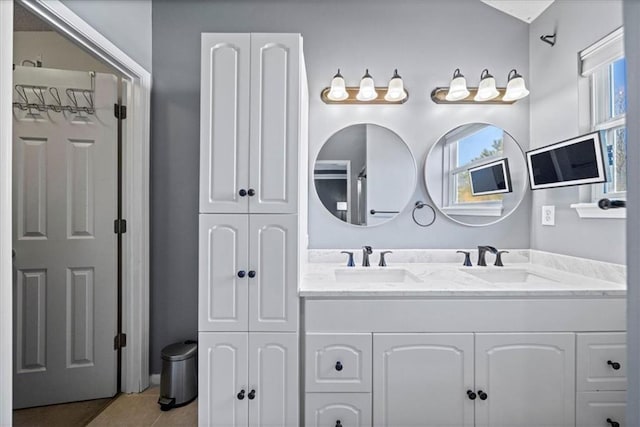 full bath with tile patterned flooring, a closet, a sink, and double vanity