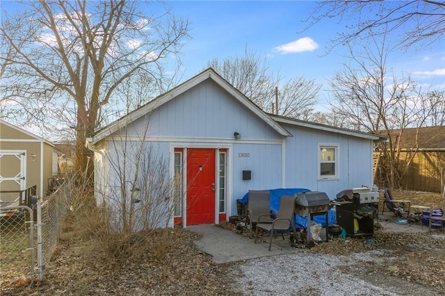 view of front facade featuring a storage unit, fence, and an outdoor structure