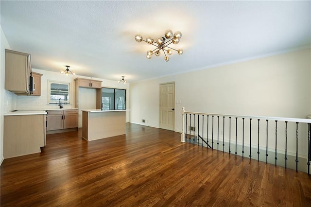 interior space with light brown cabinets, light countertops, dark wood-type flooring, and a center island