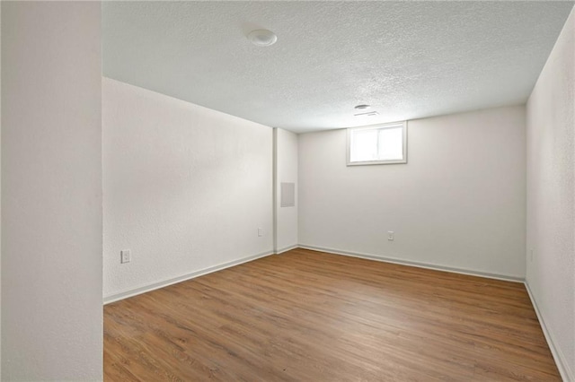 empty room featuring a textured ceiling and wood finished floors