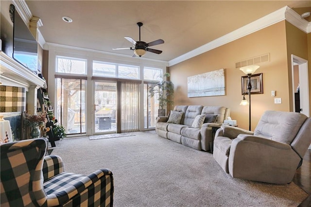 carpeted living room with ornamental molding and ceiling fan