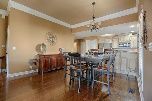 dining space featuring crown molding, dark hardwood / wood-style floors, and an inviting chandelier