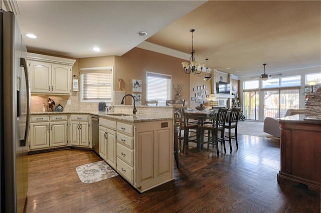 kitchen featuring sink, light stone counters, stainless steel appliances, dark hardwood / wood-style flooring, and decorative backsplash