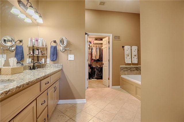 bathroom with tile patterned floors, a bathtub, and vanity