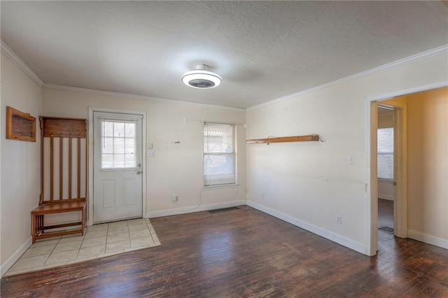 foyer entrance featuring baseboards, visible vents, ornamental molding, wood finished floors, and a textured ceiling