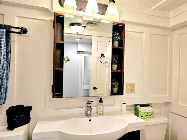 bathroom with visible vents, vanity, and toilet