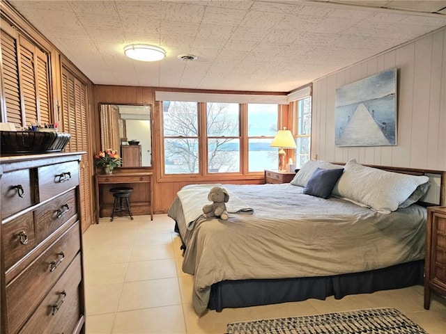 bedroom featuring multiple windows, light tile patterned flooring, and visible vents