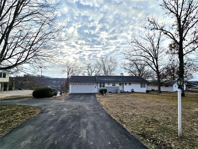 view of front of home with a garage, driveway, and a chimney