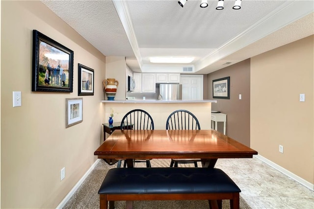 dining space with a raised ceiling, visible vents, a textured ceiling, and baseboards