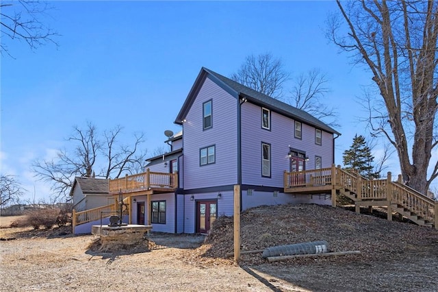 back of house featuring a wooden deck and stairs