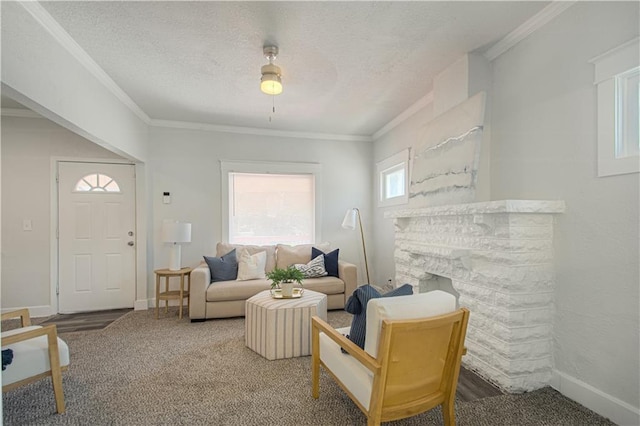 living area with a textured ceiling, a stone fireplace, ornamental molding, and baseboards