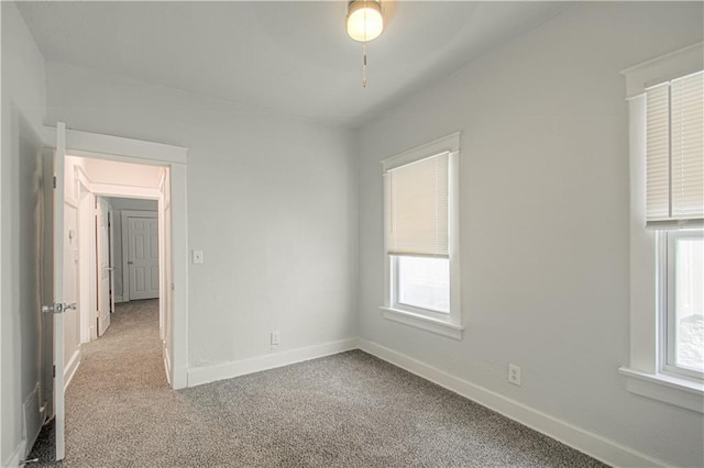 empty room featuring carpet and baseboards