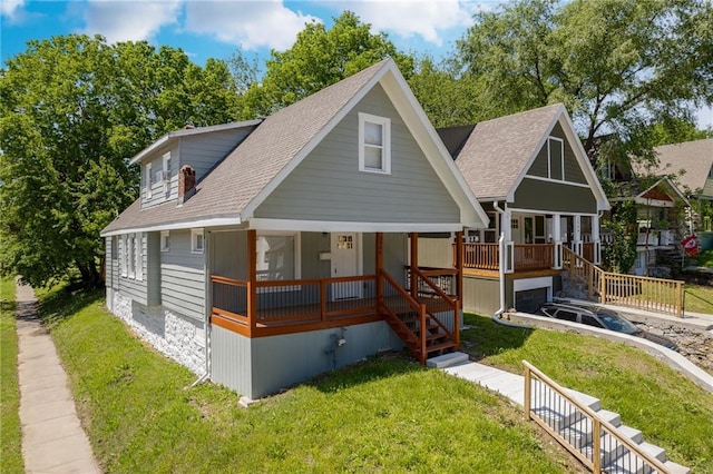 view of front facade with stairs, a porch, roof with shingles, and a front lawn