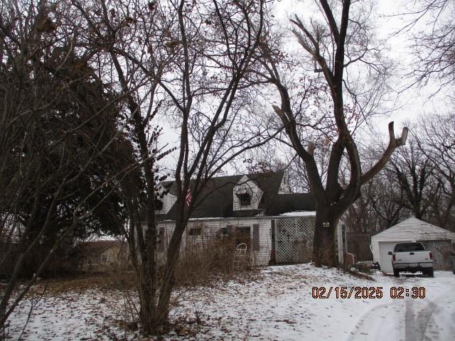 snowy yard with an outbuilding and a garage