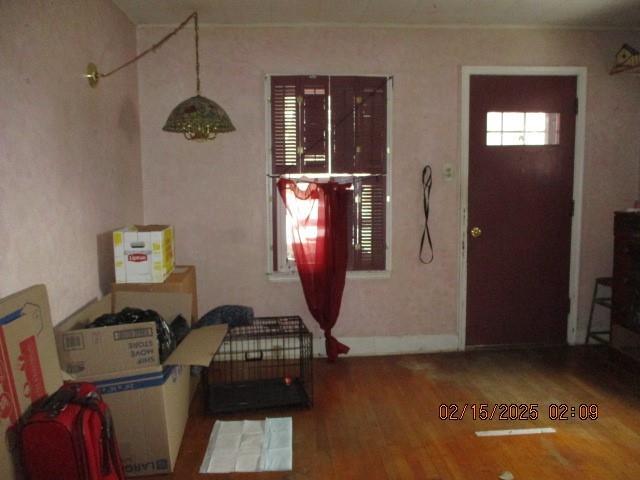 foyer with baseboards and wood finished floors