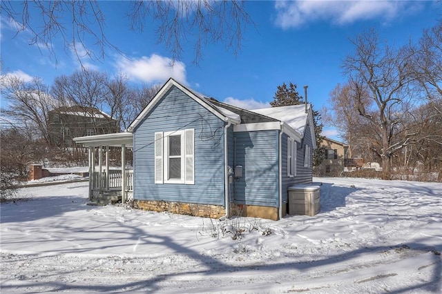 view of snowy exterior with covered porch