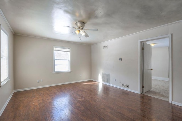 empty room featuring ornamental molding, visible vents, a ceiling fan, and wood finished floors