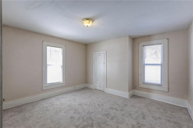 carpeted spare room with baseboards and a healthy amount of sunlight