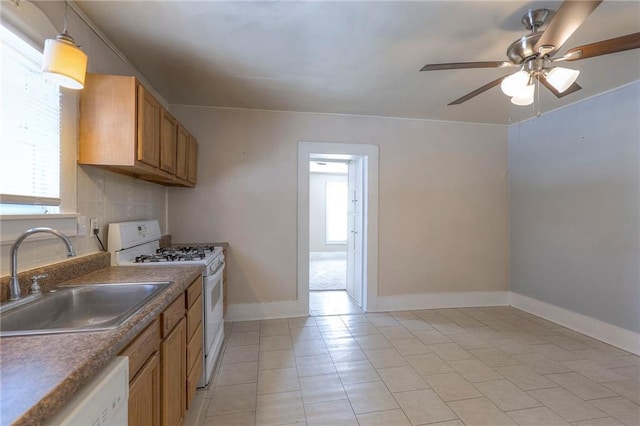 kitchen with white appliances, a sink, a ceiling fan, and a healthy amount of sunlight