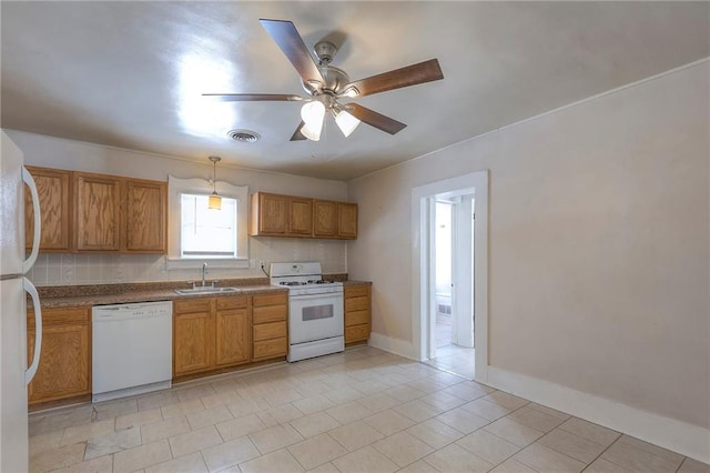 kitchen featuring light tile patterned floors, a sink, ceiling fan, white appliances, and brown cabinets