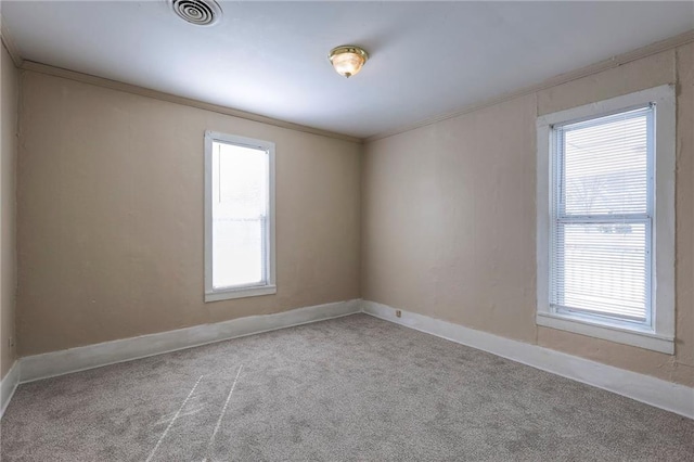 empty room with ornamental molding, visible vents, and plenty of natural light