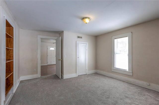 unfurnished bedroom featuring carpet flooring, visible vents, and baseboards