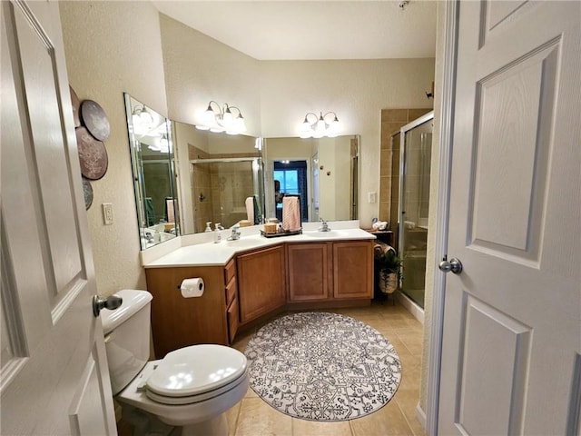 bathroom featuring double vanity, a stall shower, a sink, and tile patterned floors