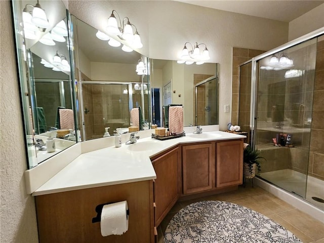 bathroom with double vanity, a stall shower, a sink, and tile patterned floors