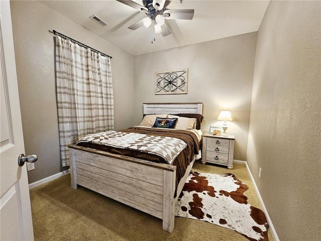 carpeted bedroom with a textured wall, a ceiling fan, visible vents, and baseboards