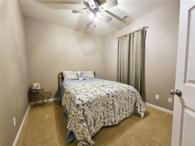 bedroom featuring baseboards, a ceiling fan, visible vents, and light colored carpet