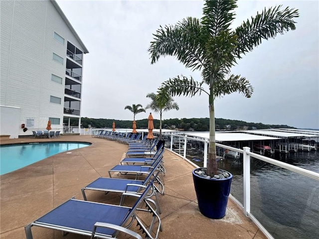 pool with a water view and a patio area