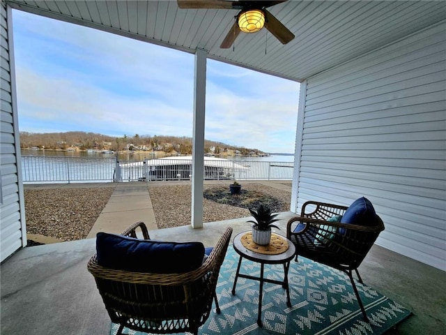 view of patio with ceiling fan, a water view, and a fenced backyard