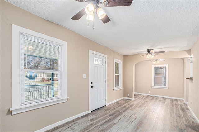 entrance foyer with ceiling fan, light wood-type flooring, and a textured ceiling