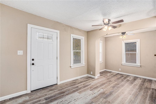 foyer featuring a textured ceiling, ceiling fan, and light hardwood / wood-style floors