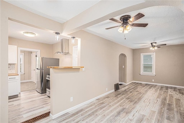 spare room with ceiling fan, light hardwood / wood-style flooring, and a textured ceiling