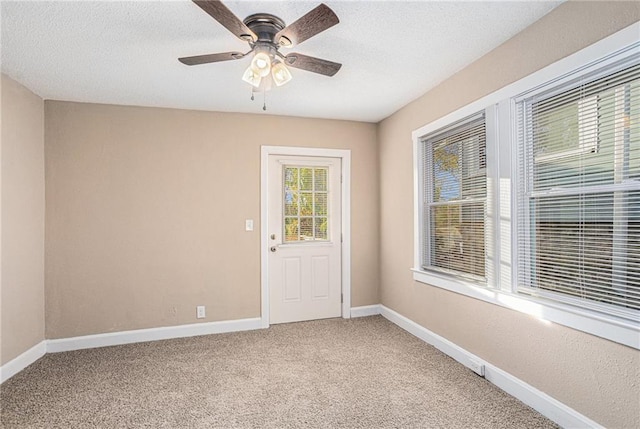 carpeted spare room with ceiling fan and a textured ceiling