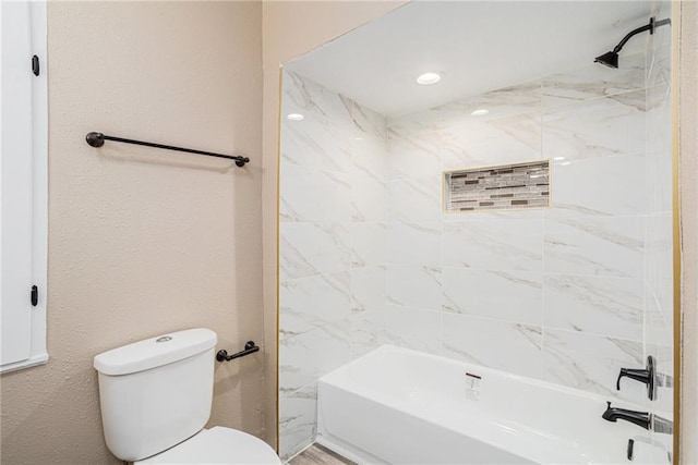 bathroom featuring toilet and tiled shower / bath