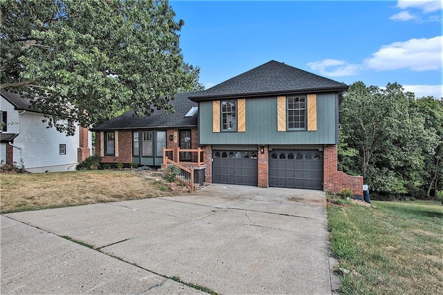 tri-level home with brick siding, an attached garage, driveway, and a front yard