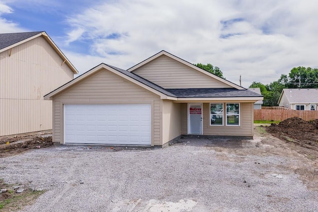 908 2nd St, Perry, KS 66073 - view of front facade with roof with shingles, an attached garage, fence, and driveway