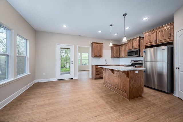 908 2nd St, Perry, KS 66073 - kitchen featuring stainless steel appliances, light wood finished floors, a center island, baseboards, and a breakfast bar area