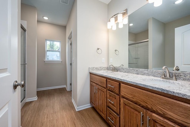 908 2nd St, Perry, KS 66073 - full bathroom featuring wood finished floors, a stall shower, baseboards, and double vanity