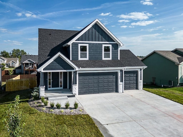 craftsman house featuring a front yard and a garage